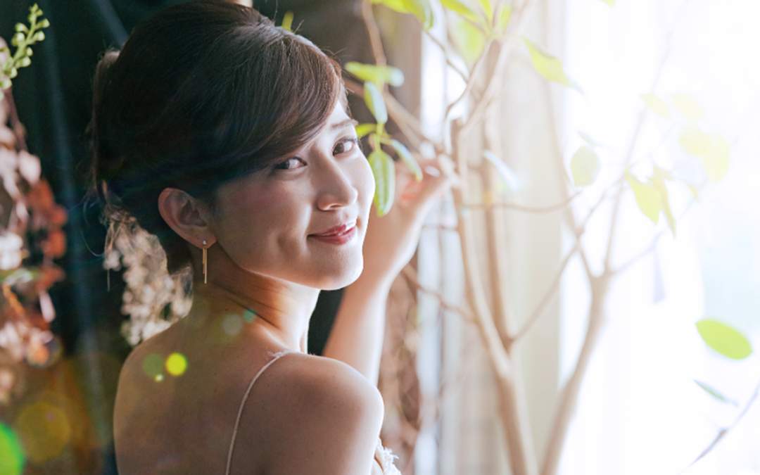 Happy bride smiling while looking over her shoulder.