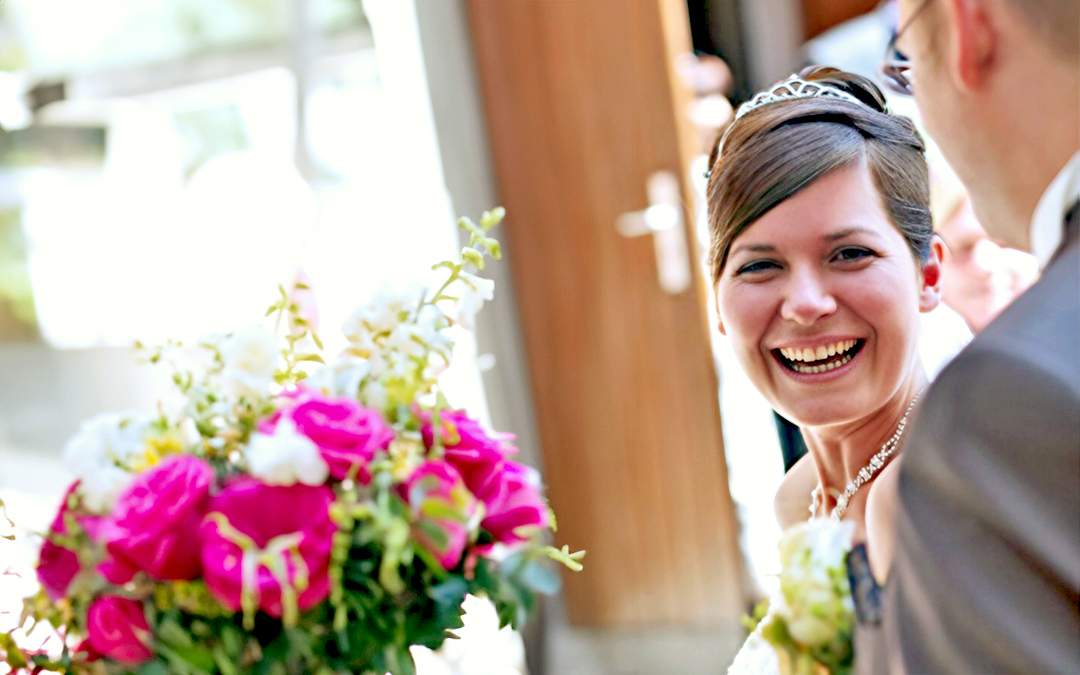 Happy bride smiling at groom.